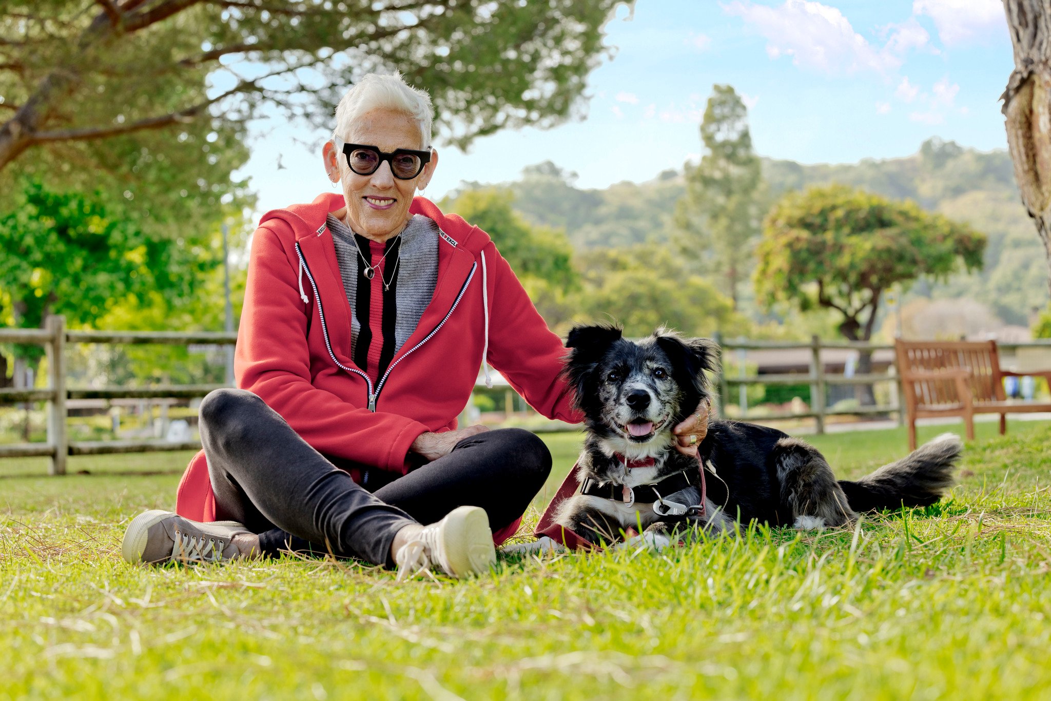 Woman seated on groudn with dog