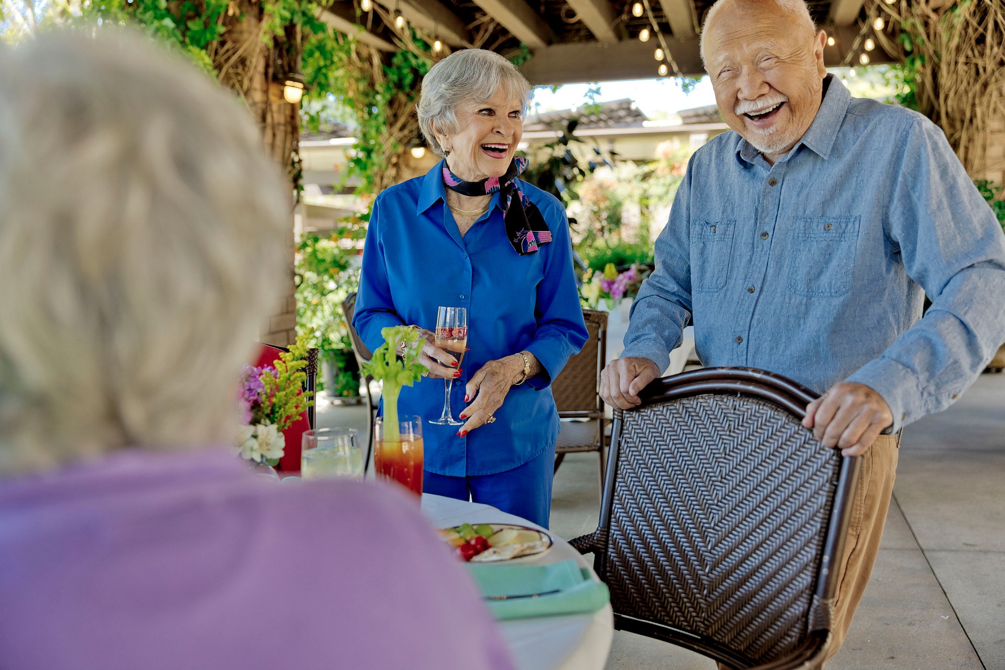 wine party  under pergola, asian man pulls out chair