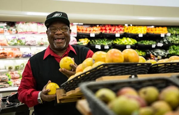 senior picking out citrus fruit at the grocery store