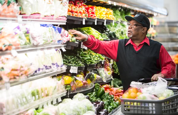 senior picking out produce at the grocery store