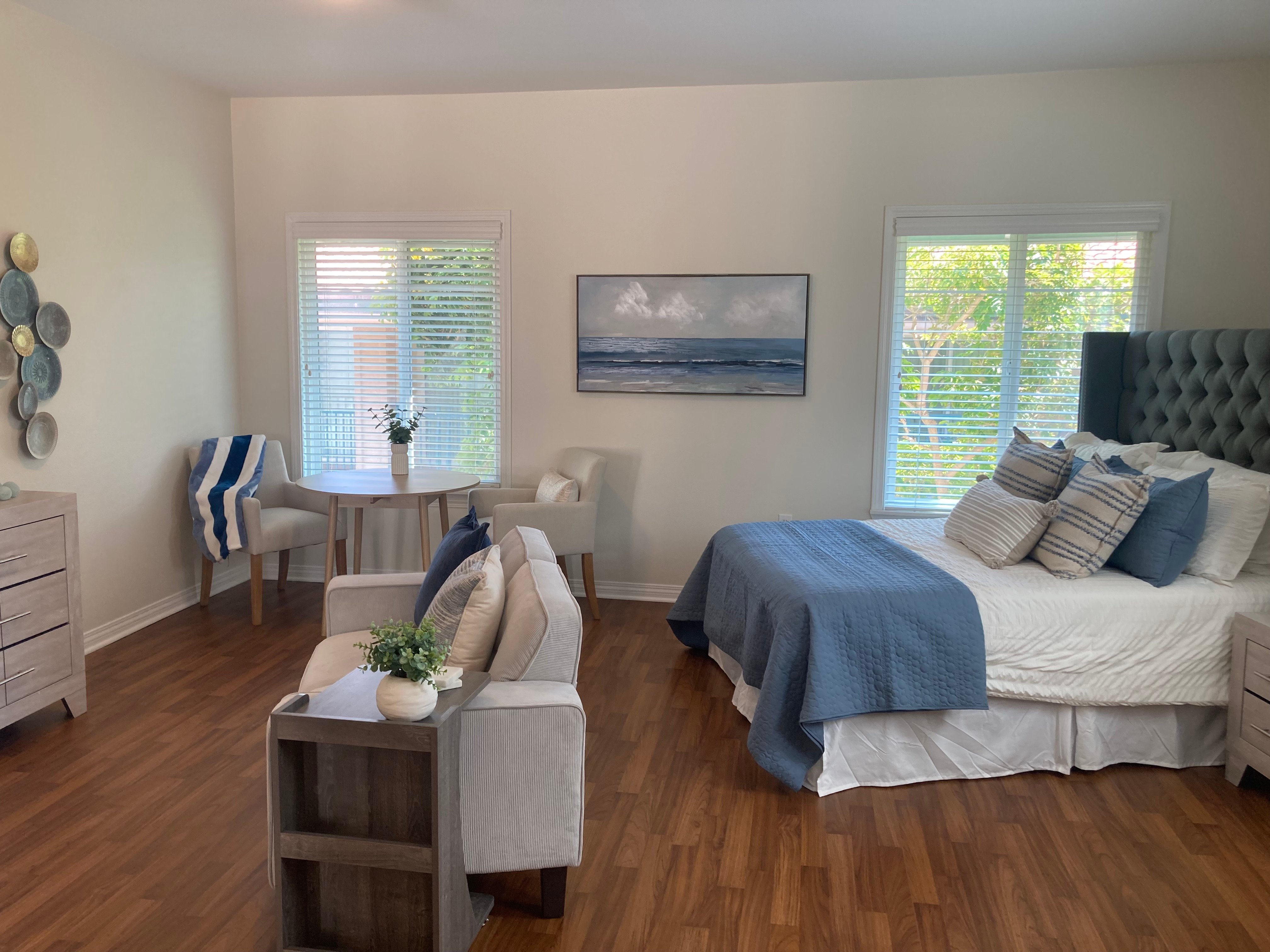 Bright, modern bedroom with blue accents and large windows.