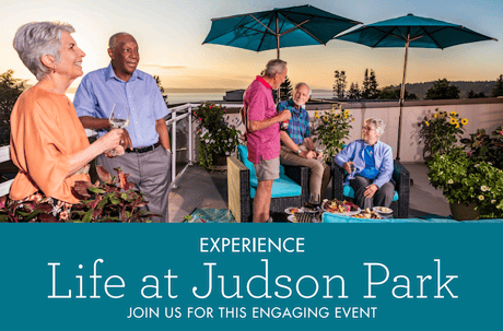 A group of seniors enjoying an outdoor rooftop gathering at sunset with drinks and food, surrounded by sunflowers and umbrellas.