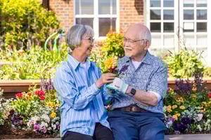 Senior woman and senior man holding flowers in the garden at The Terraces at Summitview