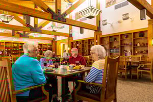 Group of four seniors eating dinner in the dining room at The Terraces of Summitview