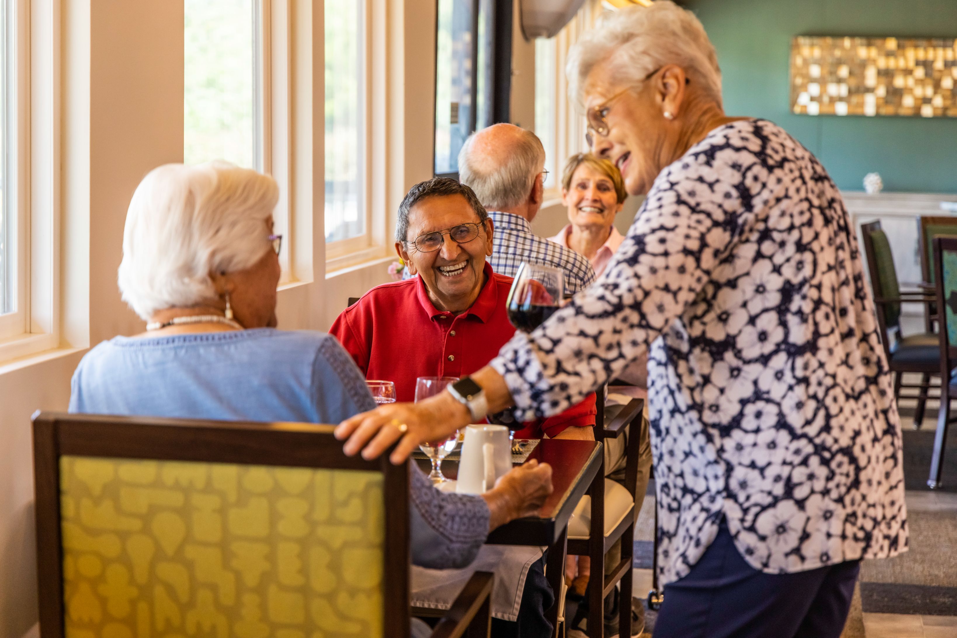 Three people laughing in dining room