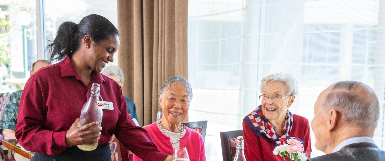 A waiter serves residents in the dining room. 