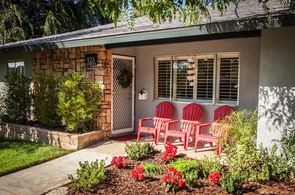 Front entrance of a Plymouth Village residence with three red chairs