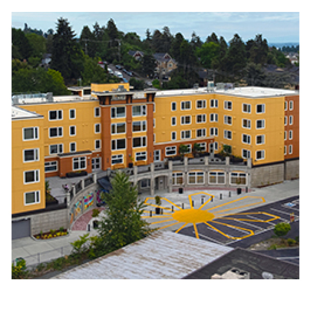 A yellow and brick apartment building. 