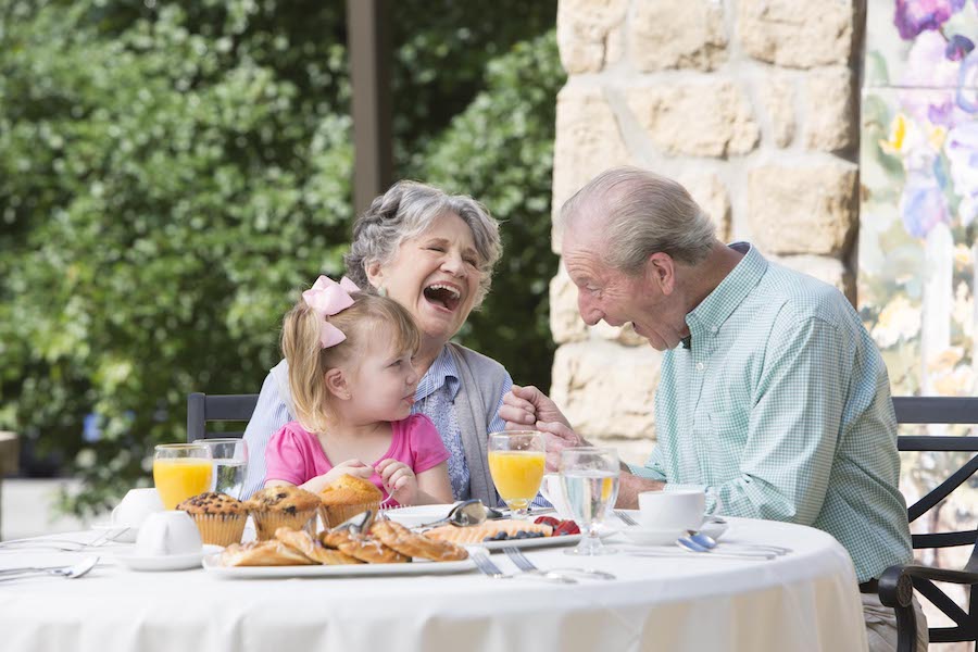Grandparents eating breakfast with grandchild