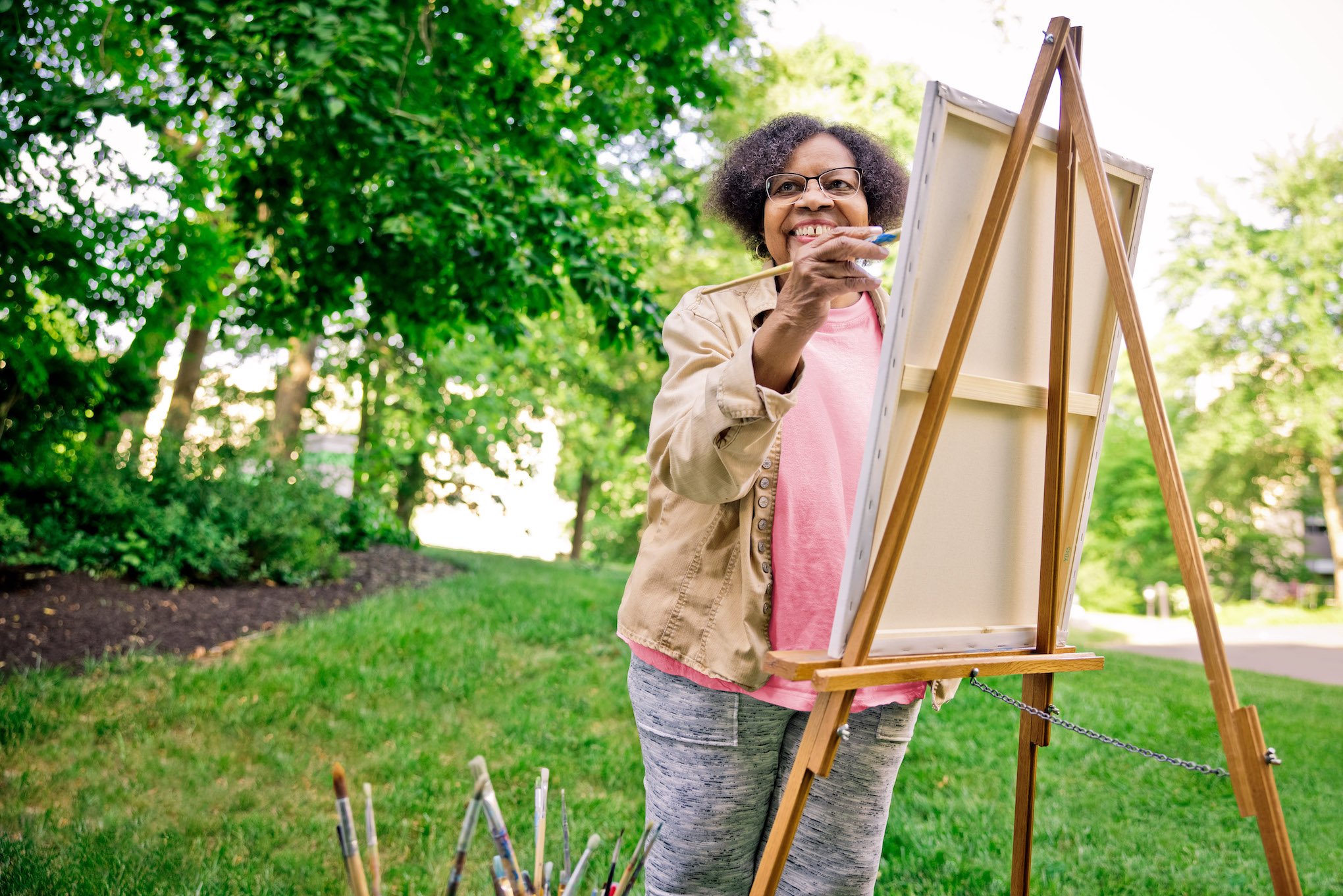 woman painting canvas on easel