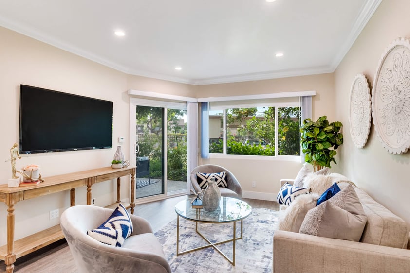 Living room with television on wall inside a Regents Point apartment home