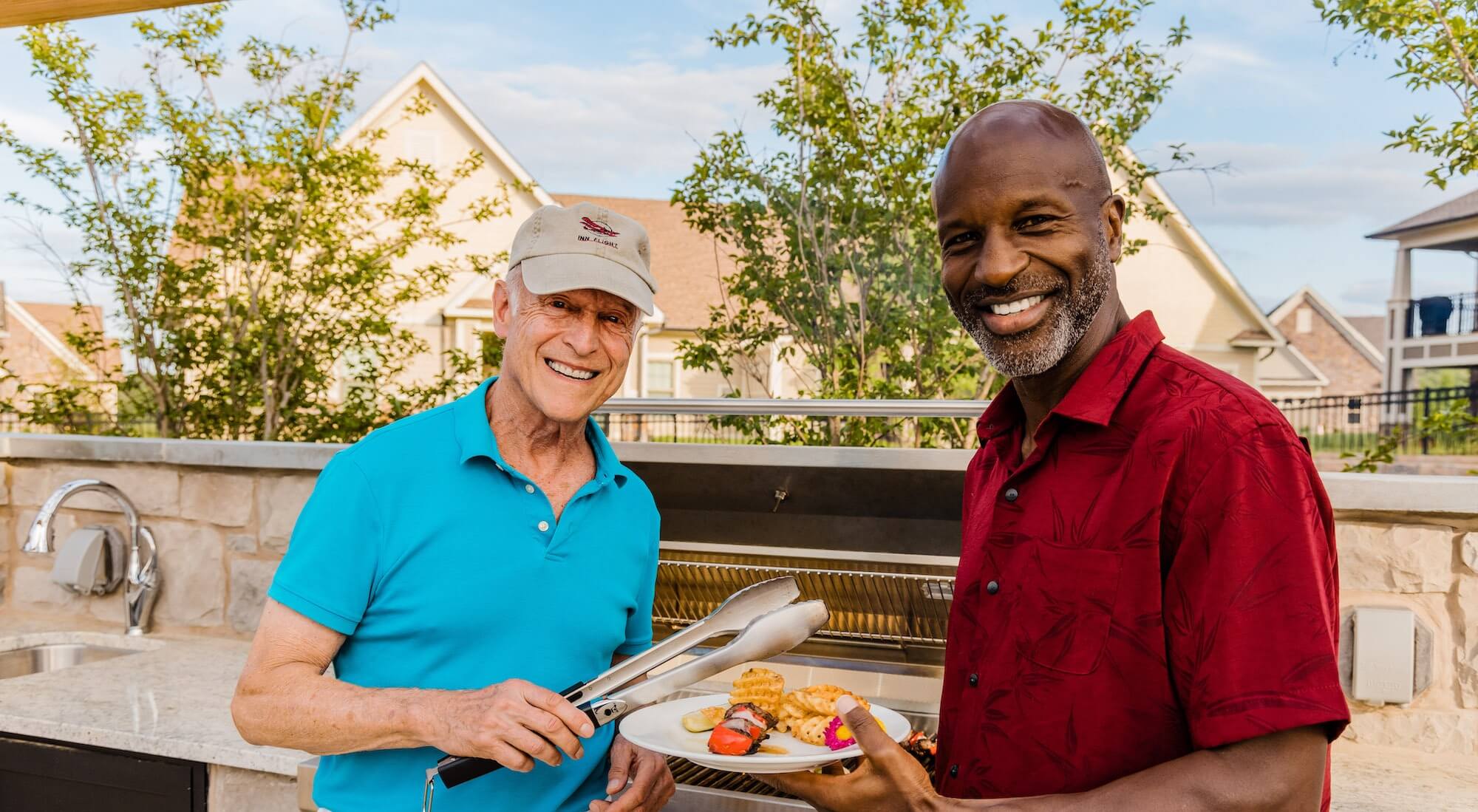Two senior men grilling at the barbecue