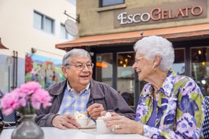 Two seniors eating outside of a gelato shop downtown