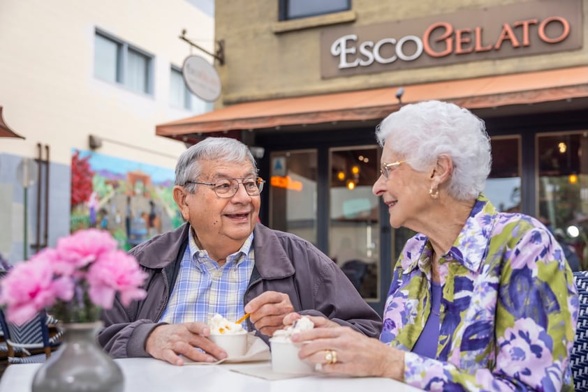 Two seniors eating outside of a gelato shop downtown