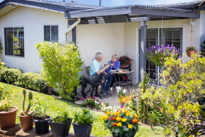 Senior couple enjoying a meal and wine on their cottage patio