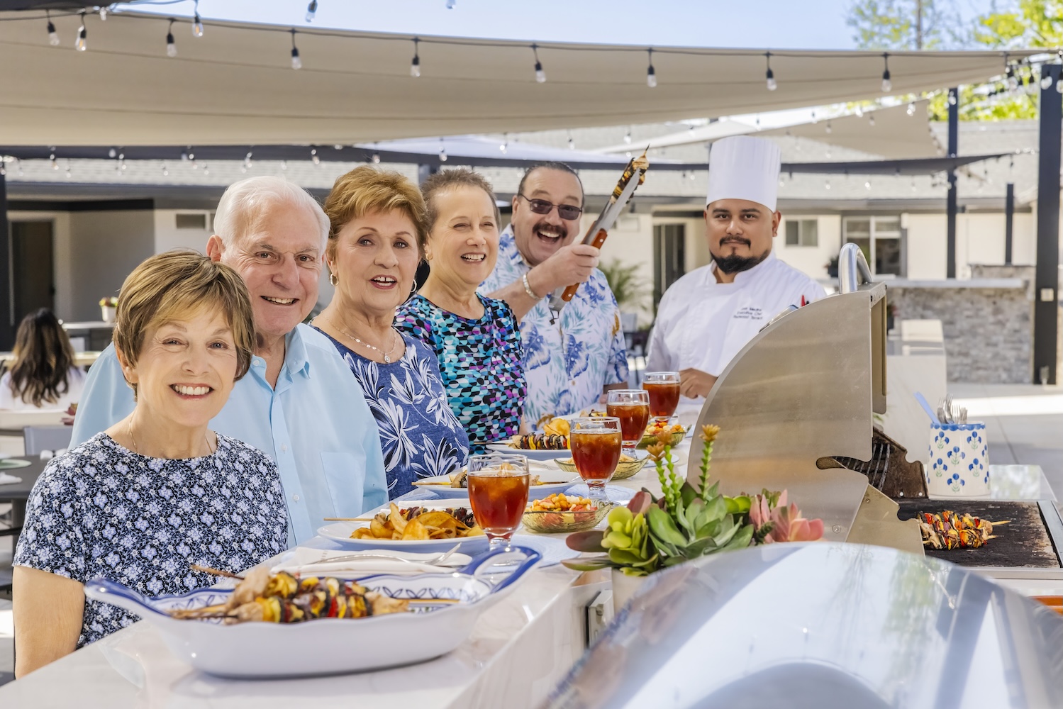 Group of seniors at an outdoor bbq with chef