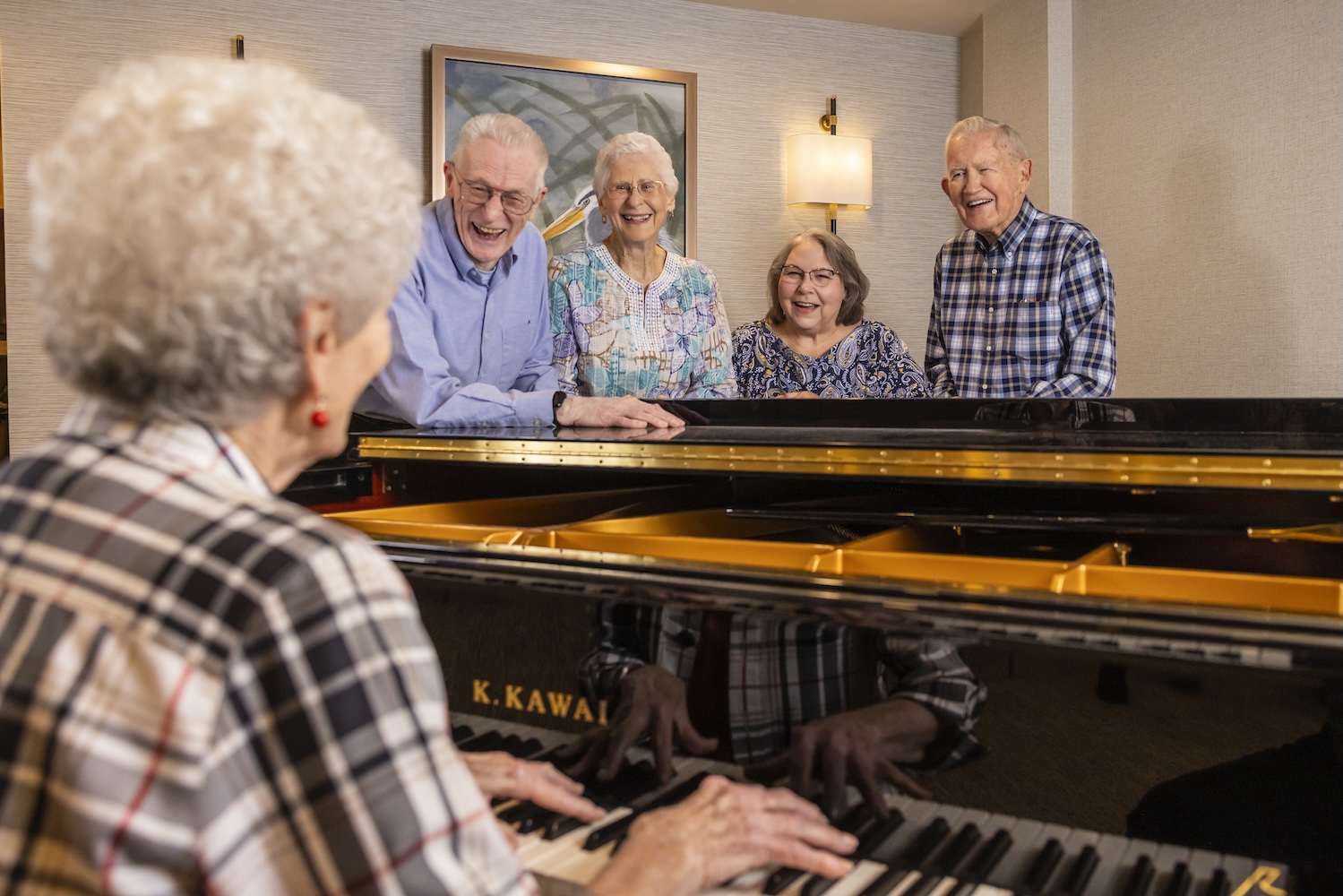 Senior woman playing the piano while four other seniors enjoying the performance