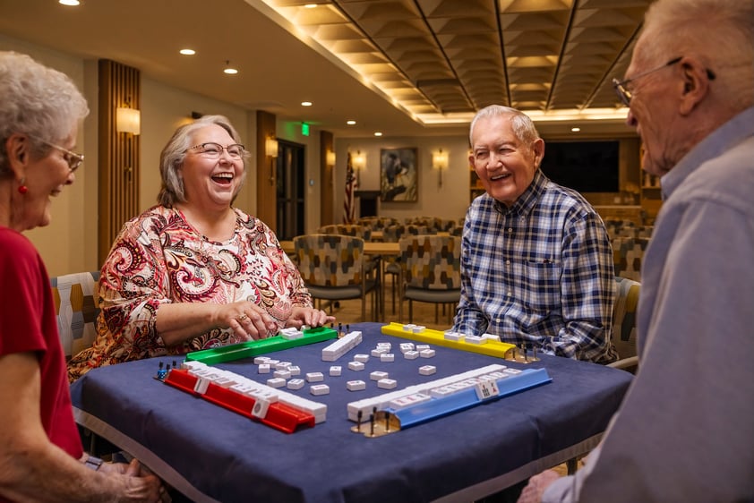 Four seniors sitting at a table playing a game