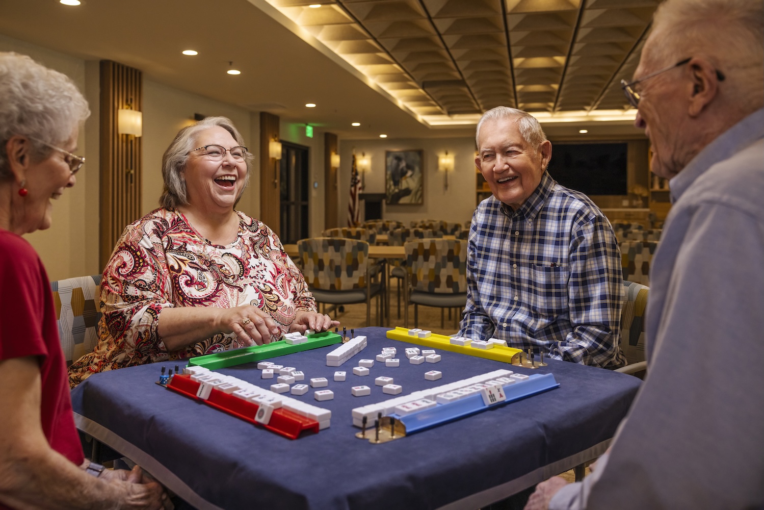 Four seniors sitting at a table playing a game