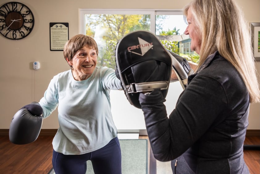 Senior woman boxing with a trainer