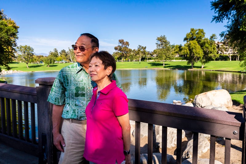 senior couple enjoying outdoor nature next to pond