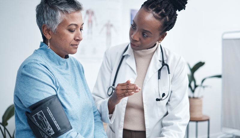 senior woman getting blood pressure taken in an exam room