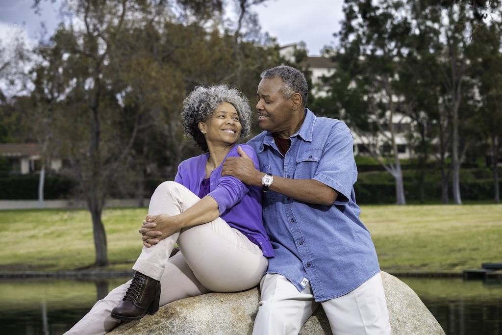 Couple sitting on a rock near the pond