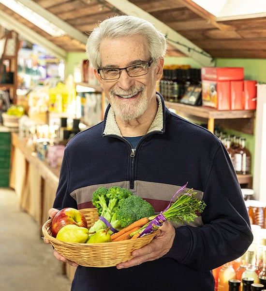 Sandy holding a basket of vegetables