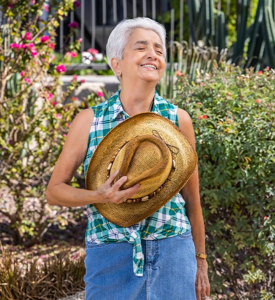 Marti outside holding a straw hat