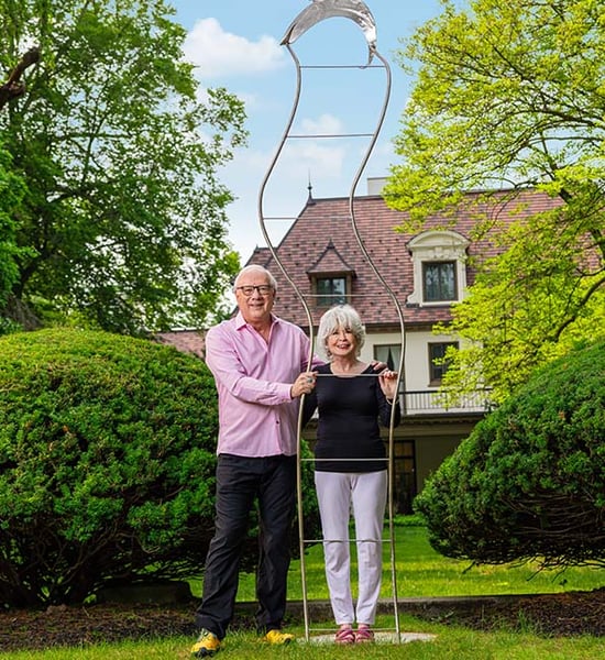 Terry and Debra posing with an outdoor metal sculpture