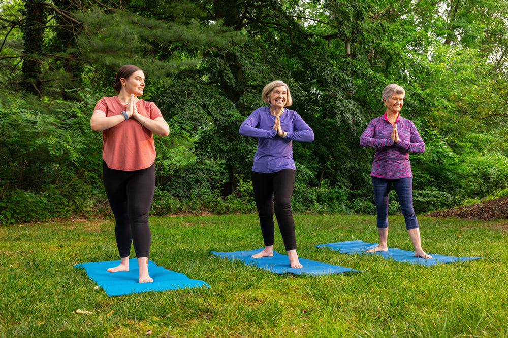 seniors doing yoga together outside