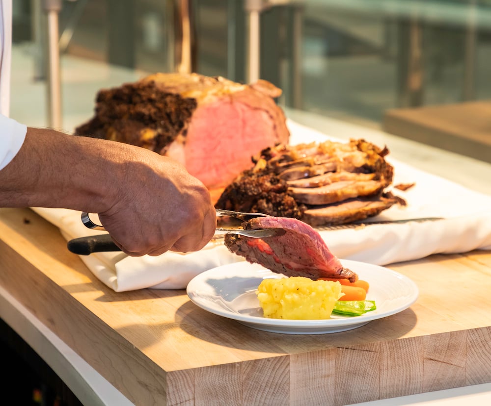 chef adding freshly cut meat to plate