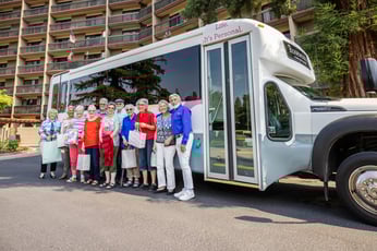 Rosewood residents on a group outing standing by the community shuttle bus.