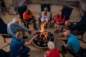 Group of seniors roasting marshmallows over an outdoor firepit