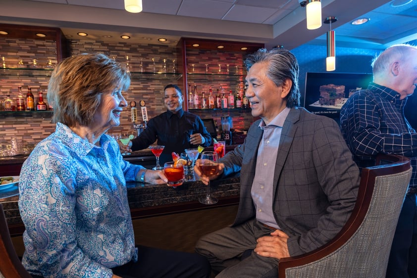 Senior man and woman enjoying a drink at the bar