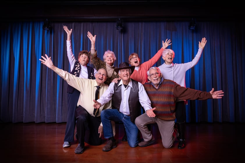 Group of seniors in front of a blue curtain onstage