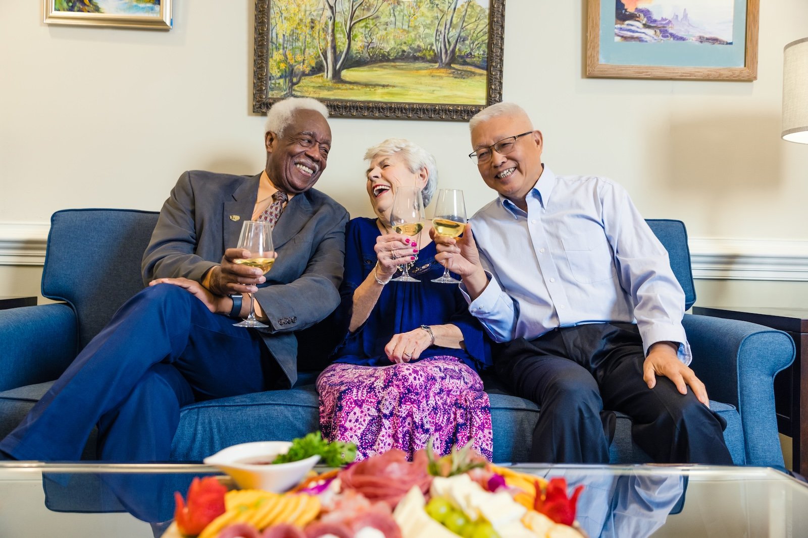 three residents on couch drinking wine