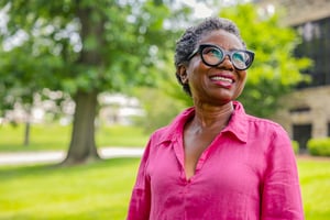 Smiling senior woman standing outside on the grounds of Spring Mill Pointe