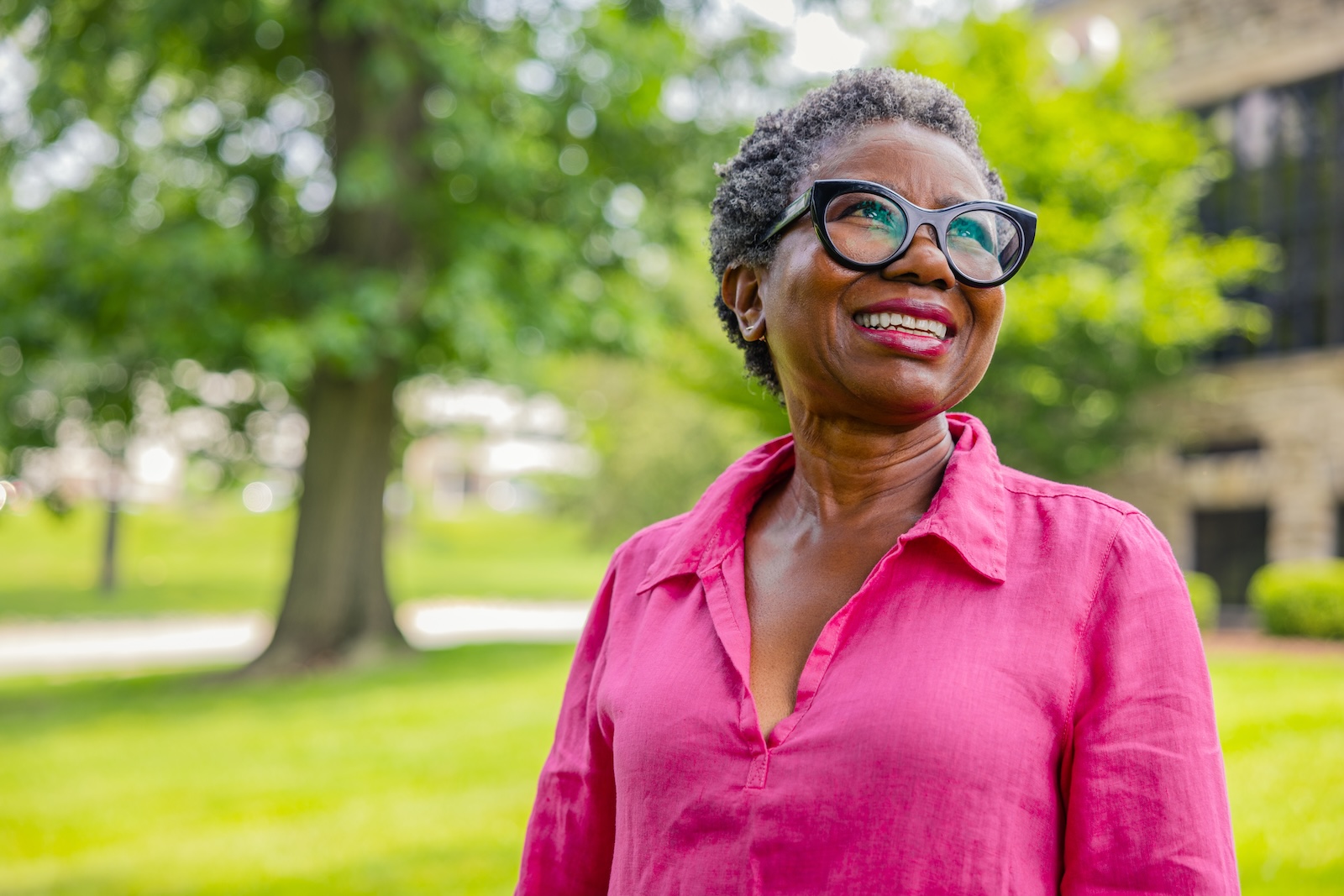 Smiling senior woman standing outside on the grounds of Spring Mill Pointe