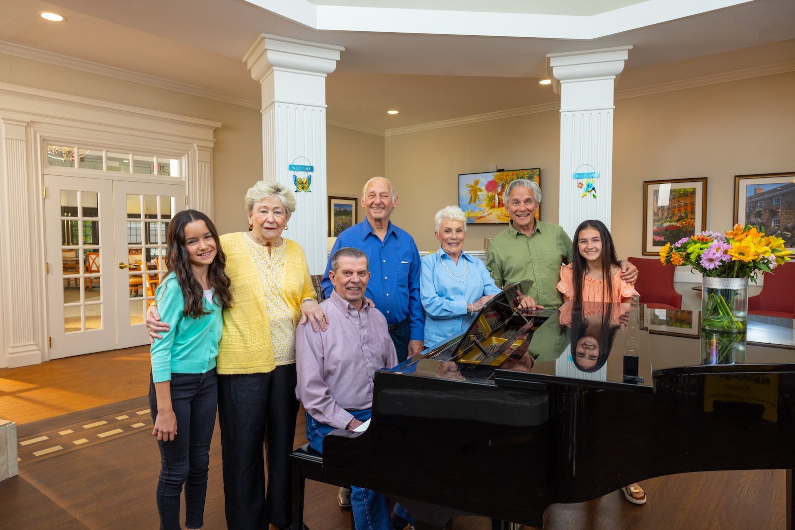 group of residents and grandchildren at piano