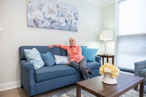 Senior woman sitting on her couch in her Spring Mill Pointe apartment