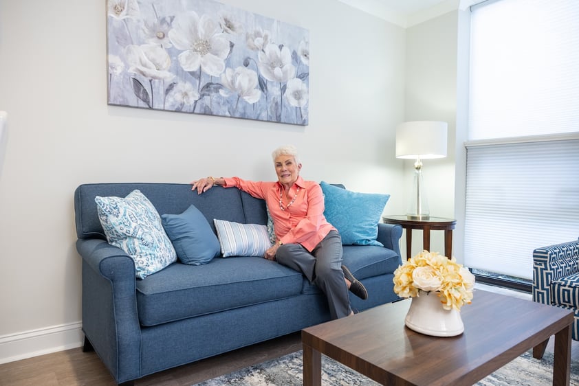 Senior woman sitting on her couch in her Spring Mill Pointe apartment
