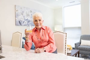 Senior woman drinking a glass of white wine in her Spring Mill Pointe apartment