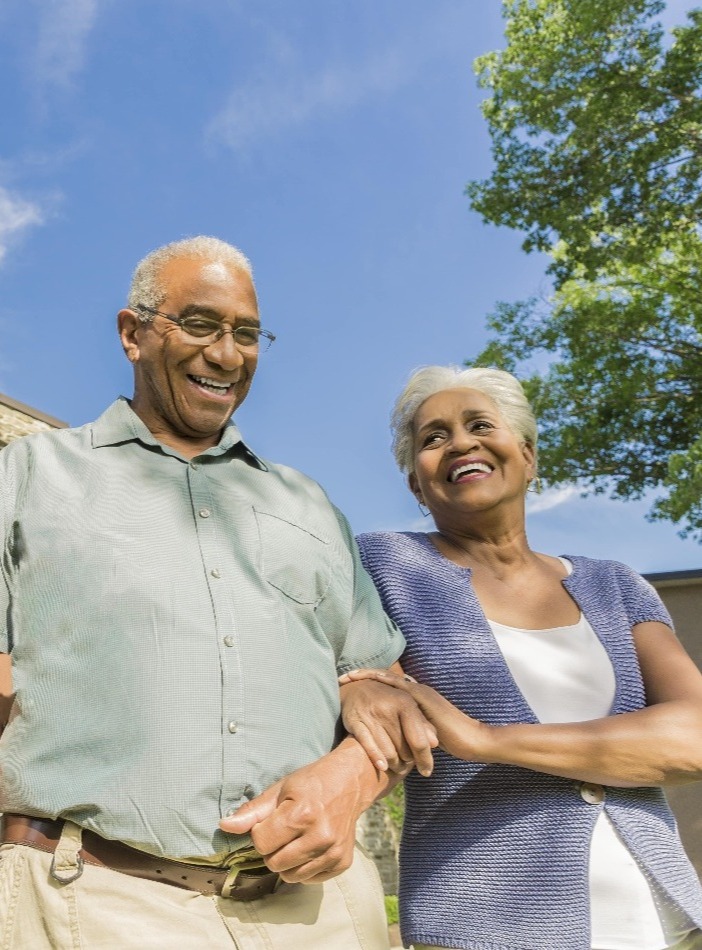 Happy couple walking outside at Spring Mill Pointe senior living community