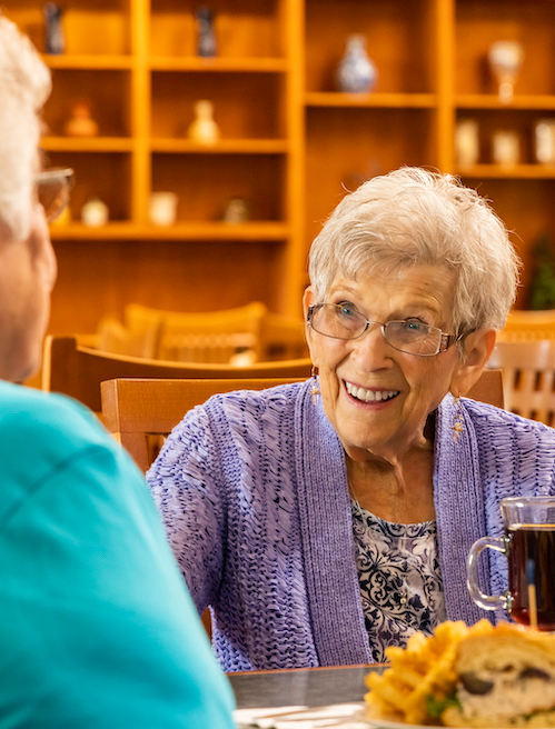 Woman sitting at a table talking to another person