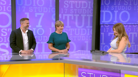 Rochelle and John from Rosewood smiling on a TV studio set at Studio 17 with the show host.