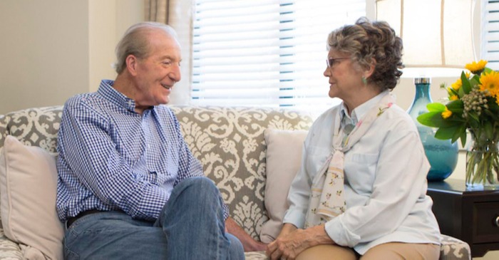 Couple sitting on a couch talking at Spring Mill Pointe