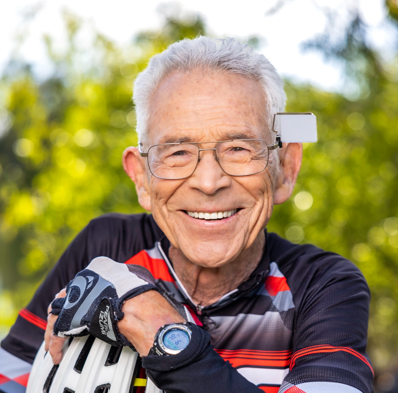 Man wearing a bicycle outfit and holding a bicycle helmet