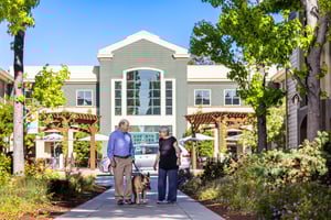 Senior couple walking a German shepherd outside The Terraces of Los Gatos