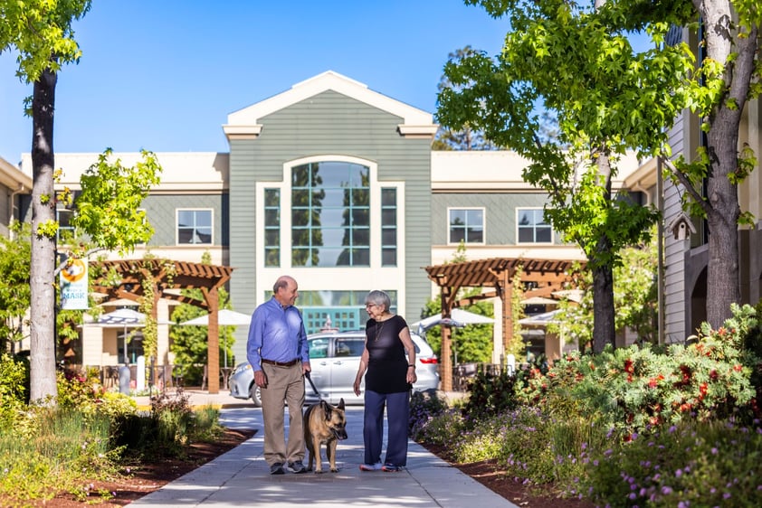 Senior couple walking a German shepherd outside The Terraces of Los Gatos